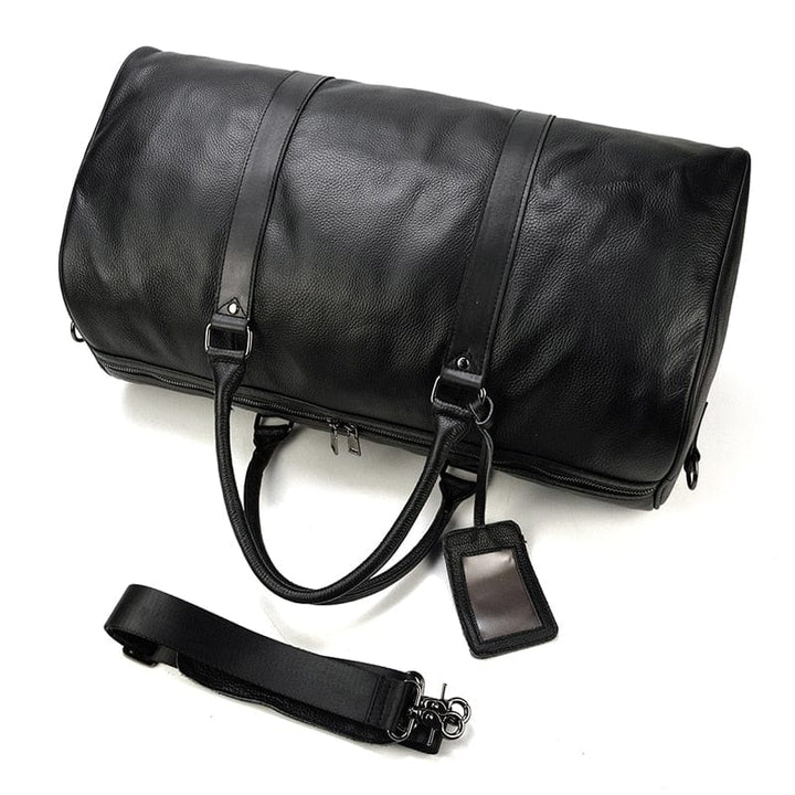 Sac de voyage élégant en cuir véritable pour femme, posé sur une valise, prêt pour le voyage, mode et luxe.
