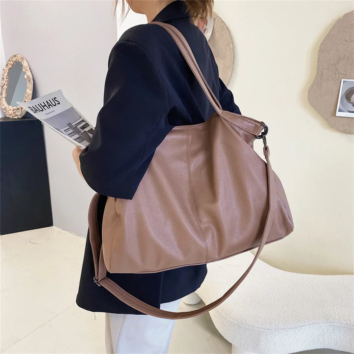 Sac hobo beige polyvalent en cuir synthétique, grand format pour femme, avec bandoulière élégante.