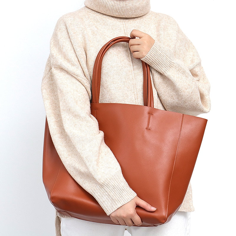 Vue détaillée de la texture du cuir véritable d'un grand sac à main femme sophistiqué.