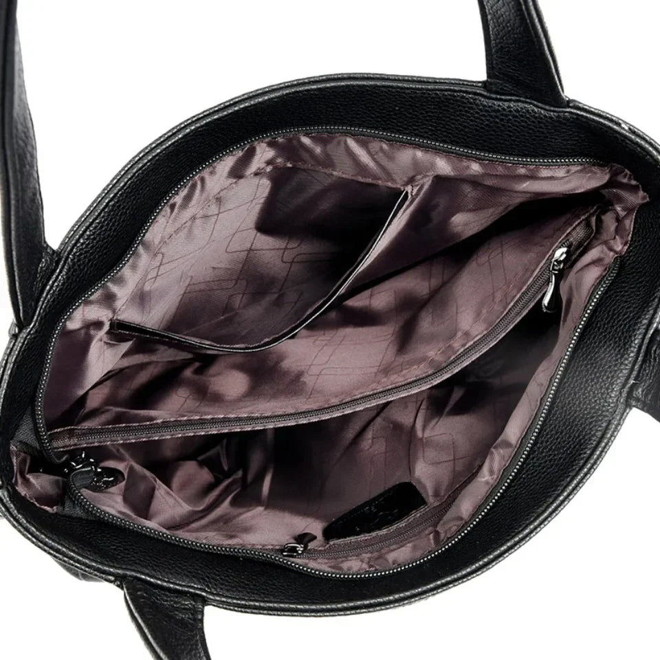 Sac fourre-tout noir moderne et élégant en cuir PU avec détails dorés pour femme, vue de face.