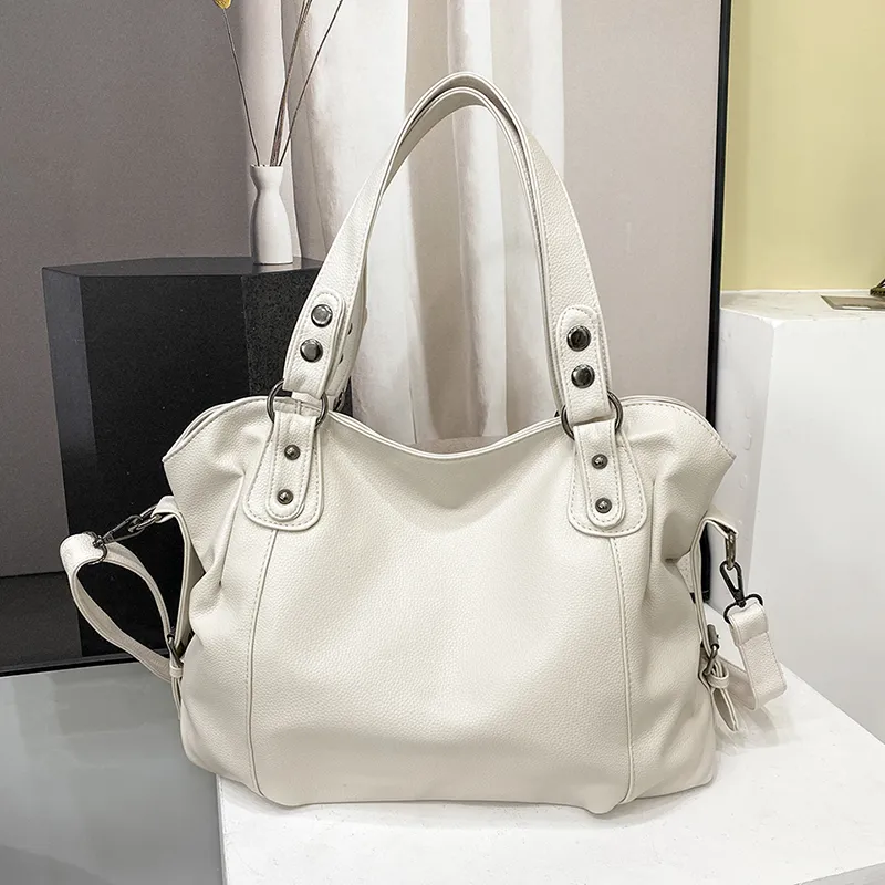 Sac bandoulière épaule en cuir pour femme, moderne et spacieux, avec plusieurs poches.