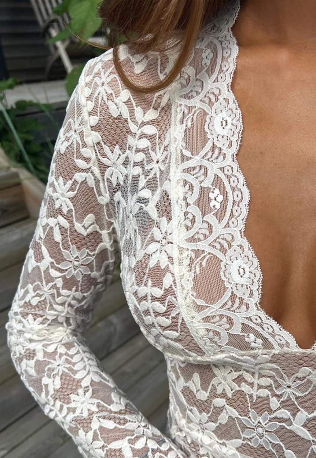 "Haut dentelle blanc féminin avec manches longues et motif floral élégant, pour un style chic et romantique."
