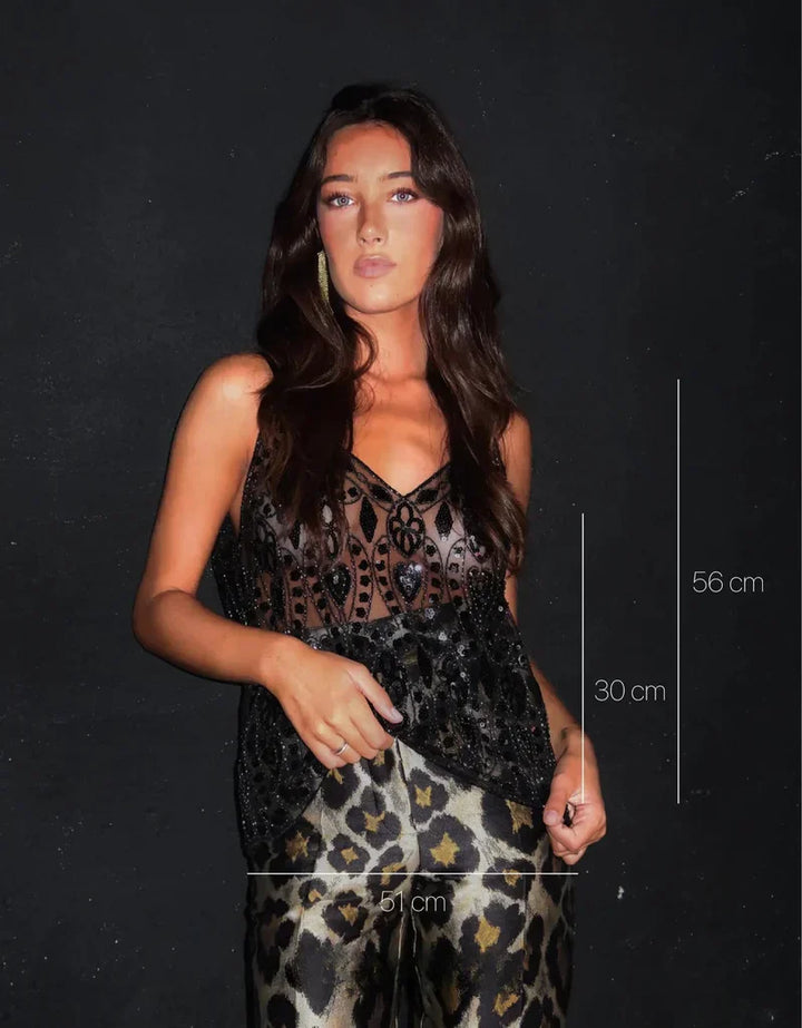 Haut polyvalent femme, élégamment orné. Confort optimal pour une tenue décontractée chic ou une soirée mode.