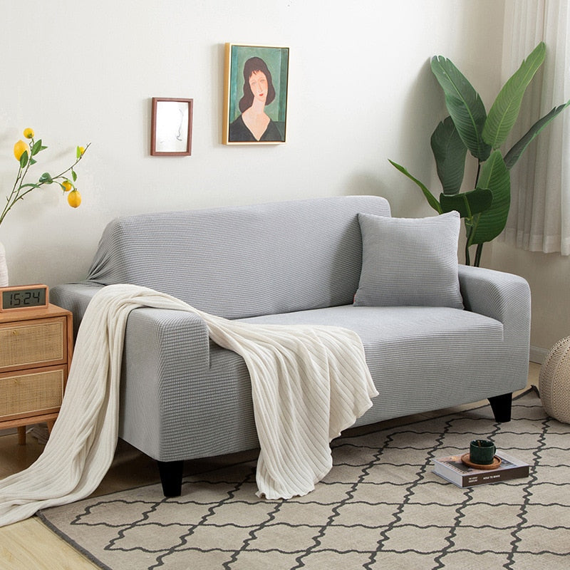 Housse de canapé extensible beige avec motif élégant et design antidérapant, disponible en plusieurs tailles pour salons mode