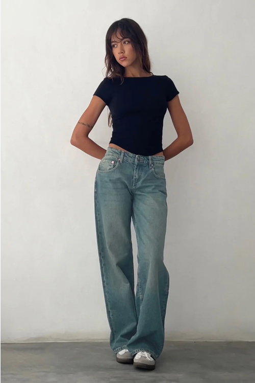 Femme portant un jean taille basse Y2K, coupe ajustée et stretch, idéal pour un look tendance et décontracté.
