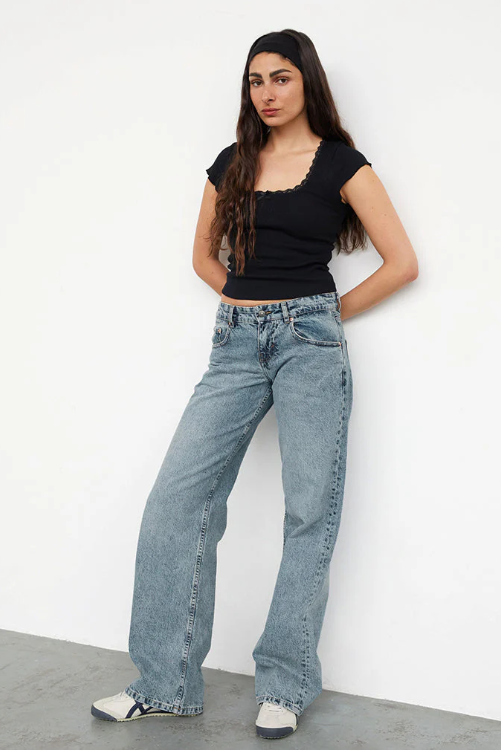 Détail du tissu denim stretch d'un jean femme taille basse, style Y2K, offrant confort et look branché.