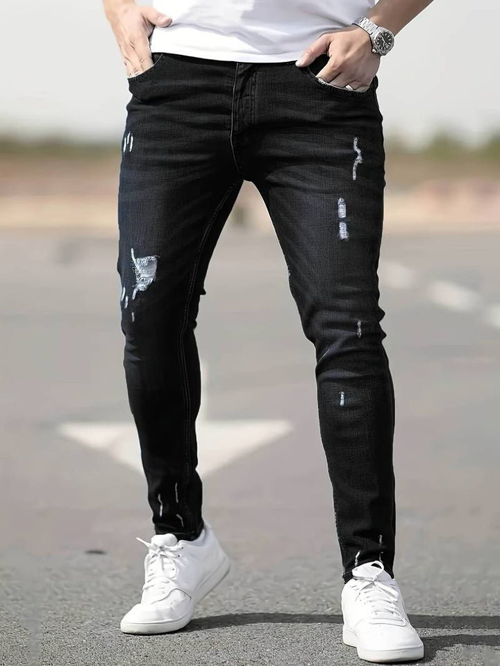 Gros plan sur la texture du denim stretch des jeans slim-fit pour homme.