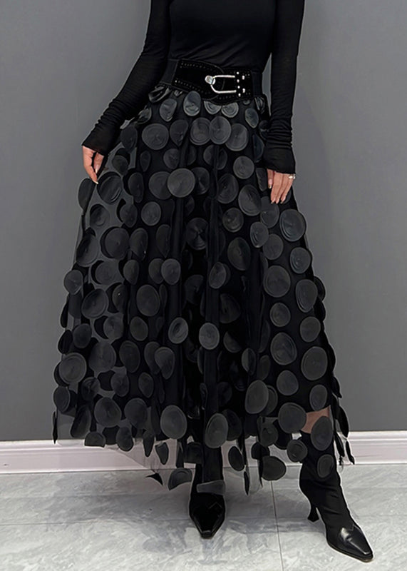 Détail d'une jupe en tulle à pois, montrant le tissu aérien et le design élégant du patchwork.