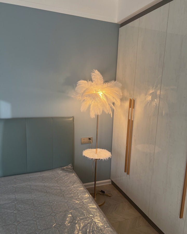 Lampadaire plumeux avec plateau intégré.  Éclairage ambiance chaleureux. Design palmier élégant et fonctionnel.