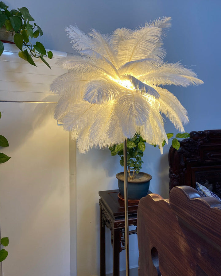 Lampadaire plumeux avec plateau intégré.  Éclairage ambiance chaleureux. Design palmier élégant et fonctionnel.