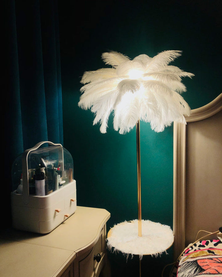 Lampadaire plumeux avec plateau intégré.  Éclairage ambiance chaleureux. Design palmier élégant et fonctionnel.