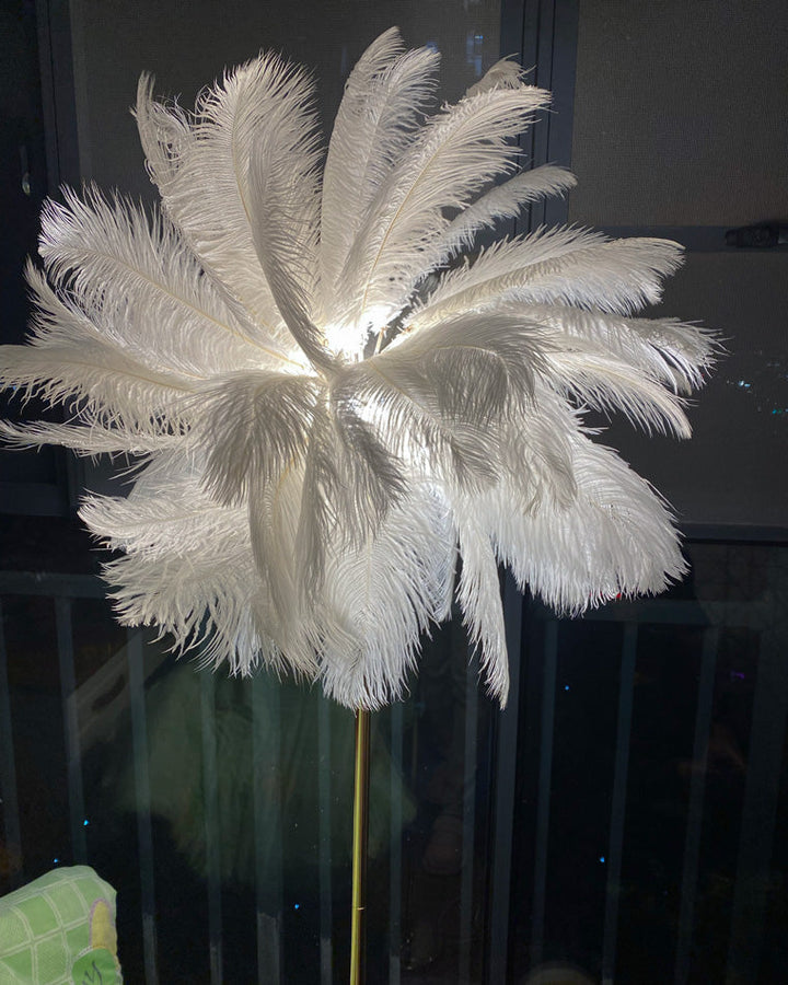 Lampadaire plumeux avec plateau intégré.  Éclairage ambiance chaleureux. Design palmier élégant et fonctionnel.