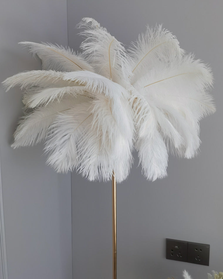 Lampadaire plumeux avec plateau intégré.  Éclairage ambiance chaleureux. Design palmier élégant et fonctionnel.