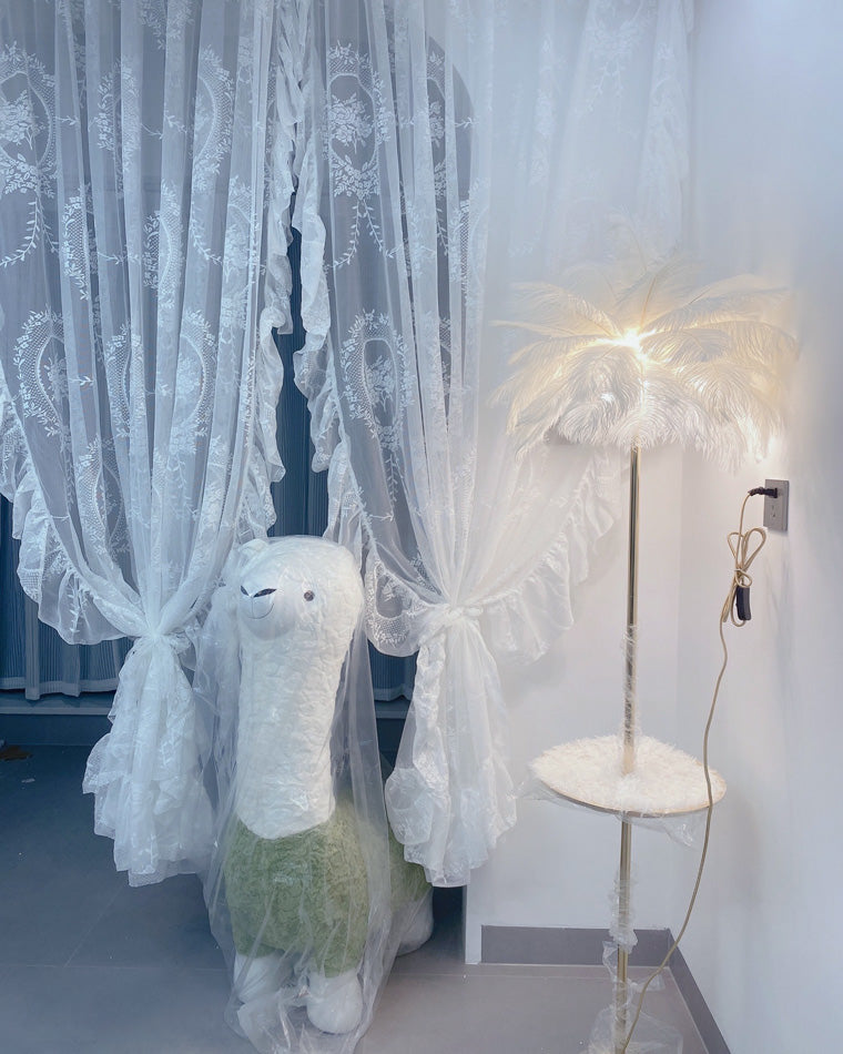 Lampadaire plumeux avec plateau intégré.  Éclairage ambiance chaleureux. Design palmier élégant et fonctionnel.