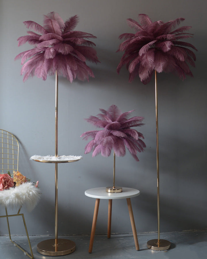 Lampadaire plumeux avec plateau intégré.  Éclairage ambiance chaleureux. Design palmier élégant et fonctionnel.
