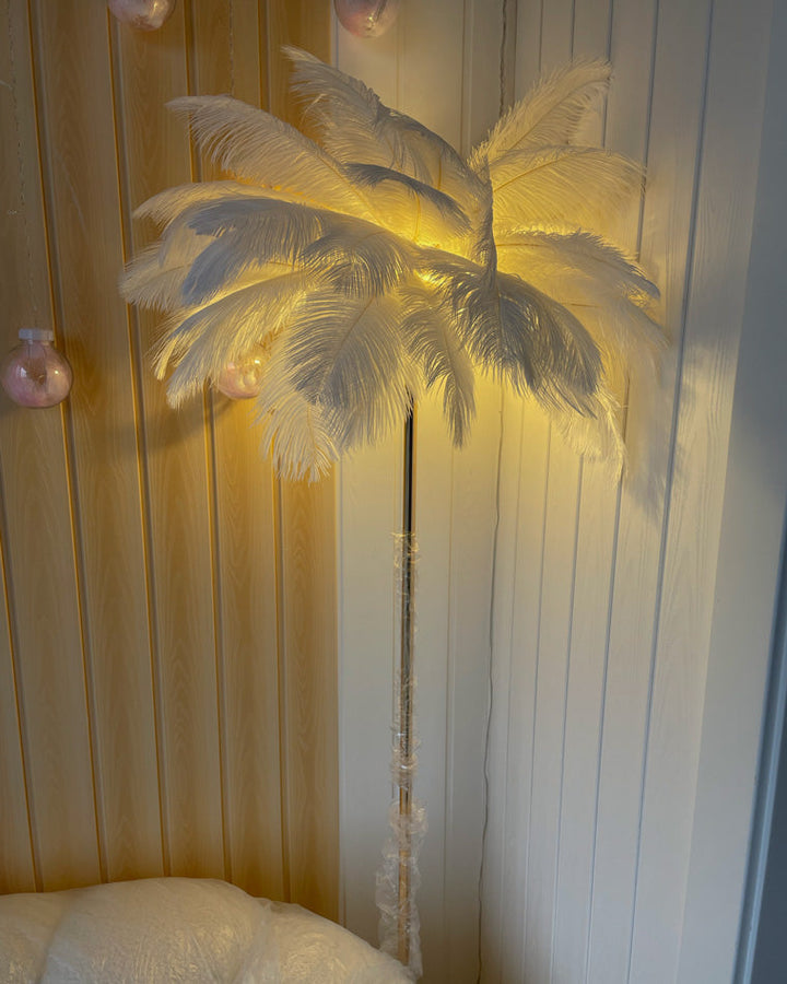 Lampadaire plumeux avec plateau intégré.  Éclairage ambiance chaleureux. Design palmier élégant et fonctionnel.
