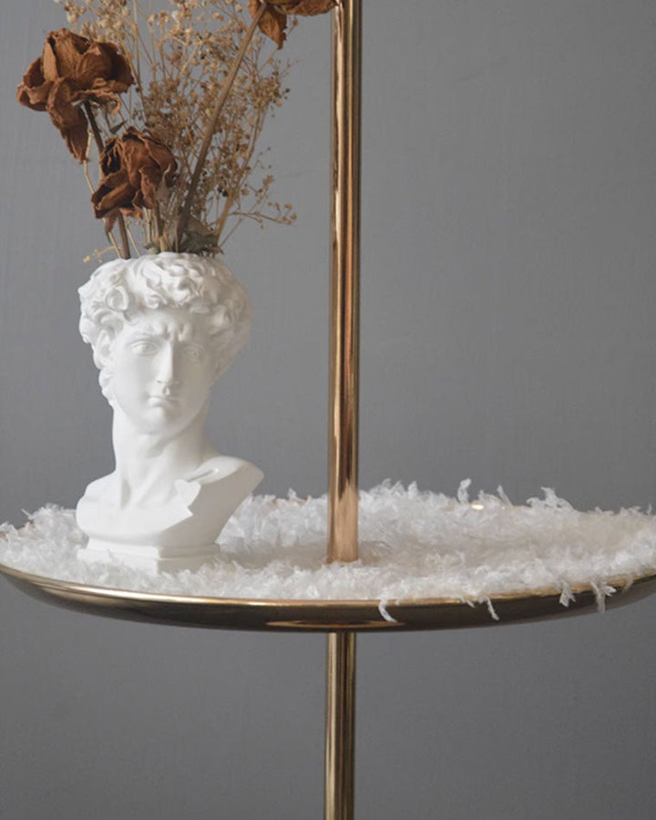Lampadaire plumeux avec plateau intégré.  Éclairage ambiance chaleureux. Design palmier élégant et fonctionnel.