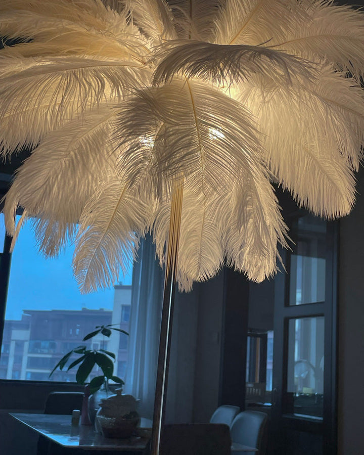 Lampadaire plumeux avec plateau intégré.  Éclairage ambiance chaleureux. Design palmier élégant et fonctionnel.