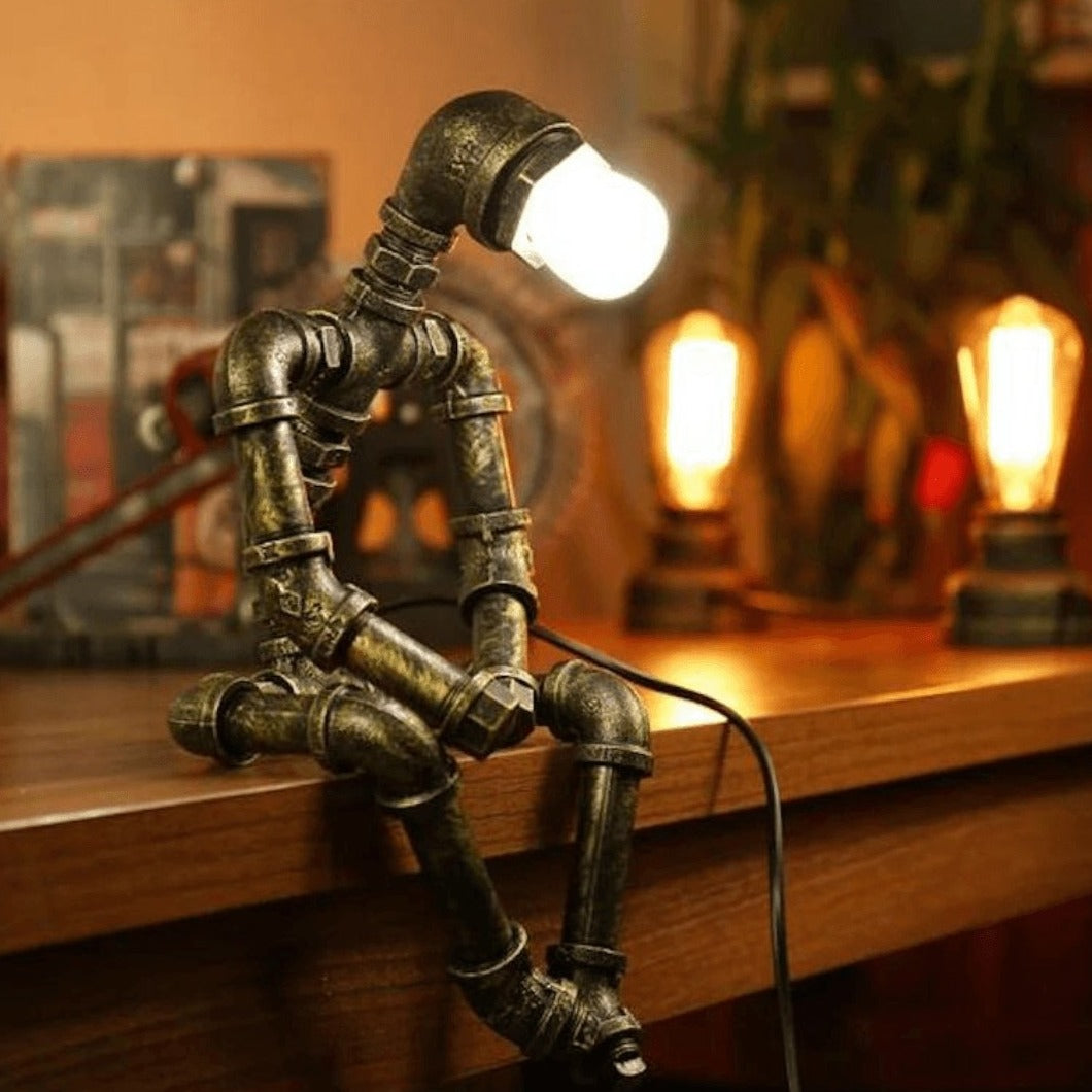 Lampe robot industrielle en fer, style rétro chic, bras et tête ajustables, finition laiton, design tuyaux industriels.