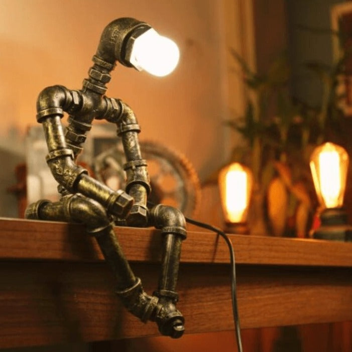 Lampe robot industrielle en fer, style rétro chic, bras et tête ajustables, finition laiton, design tuyaux industriels.
