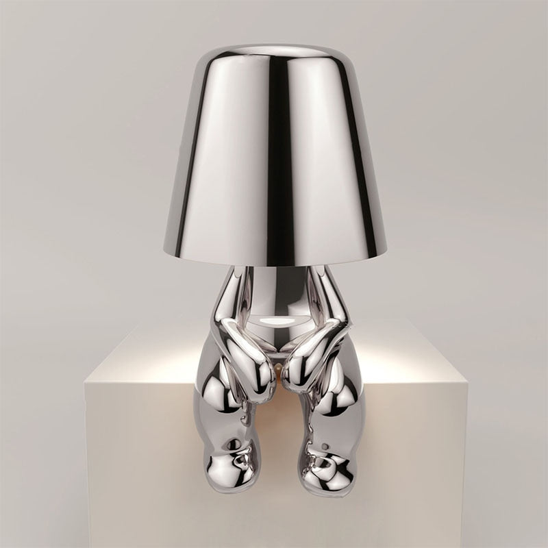 "Lampe sans fil moderne sur table, finition argentée, diffusant une douce lumière chaleureuse, design élégant et chic."
