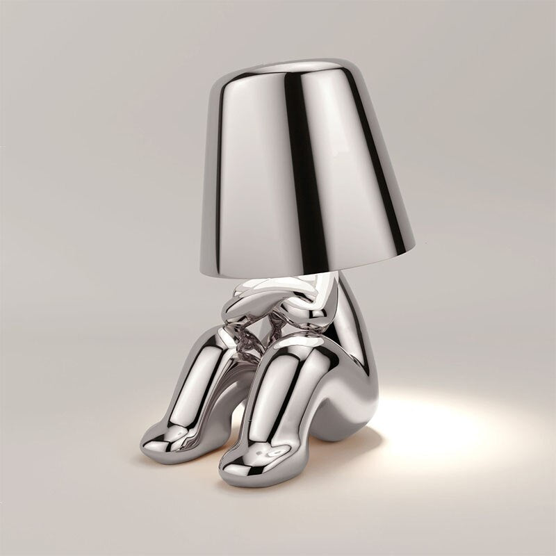 "Lampe sans fil moderne sur table, finition argentée, diffusant une douce lumière chaleureuse, design élégant et chic."
