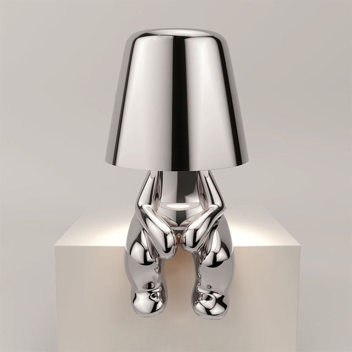"Lampe sans fil moderne sur table, finition argentée, diffusant une douce lumière chaleureuse, design élégant et chic."