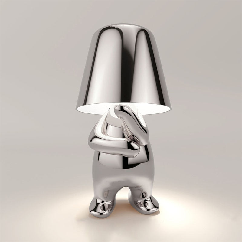 "Lampe sans fil moderne sur table, finition argentée, diffusant une douce lumière chaleureuse, design élégant et chic."