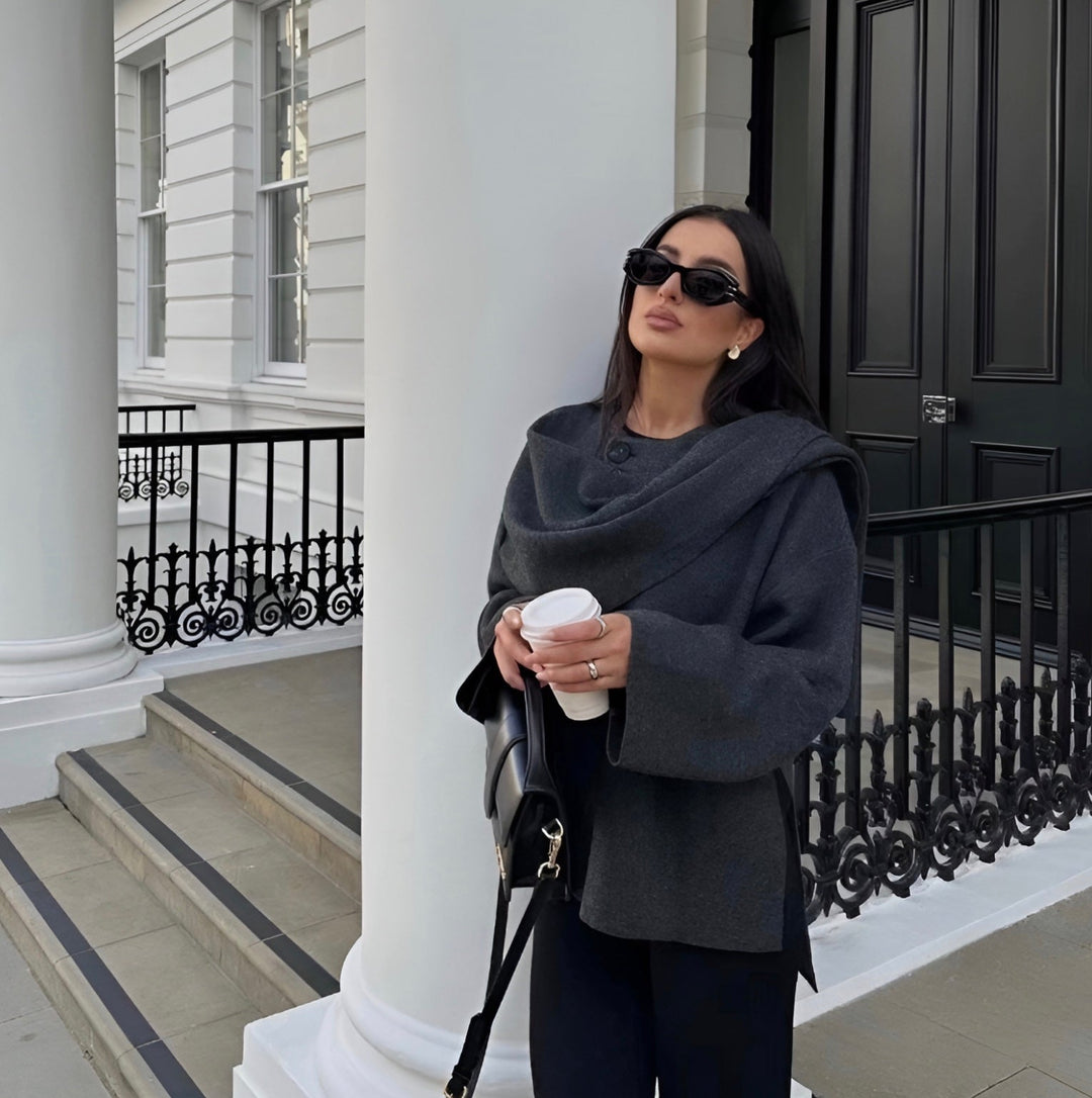 "Manteau cape femme chic automne, design asymétrique gris, tissu doux, style moderne et confortable pour temps frais."