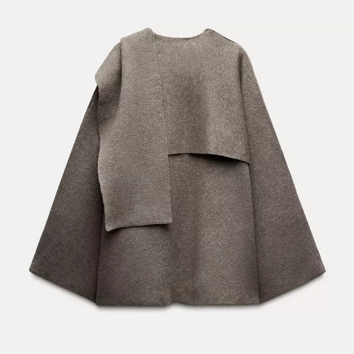 "Manteau cape femme chic automne, design asymétrique gris, tissu doux, style moderne et confortable pour temps frais."