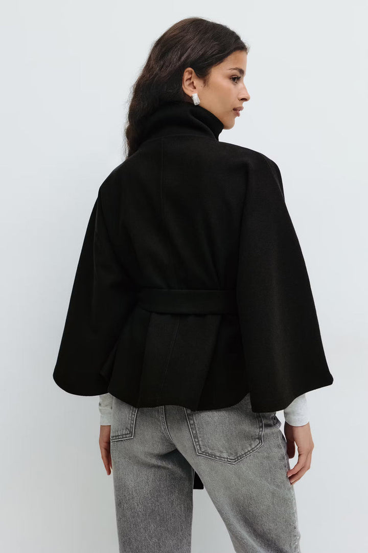 Élégant manteau cape pour femme, col montant et ceinturé, idéal pour la saison froide.