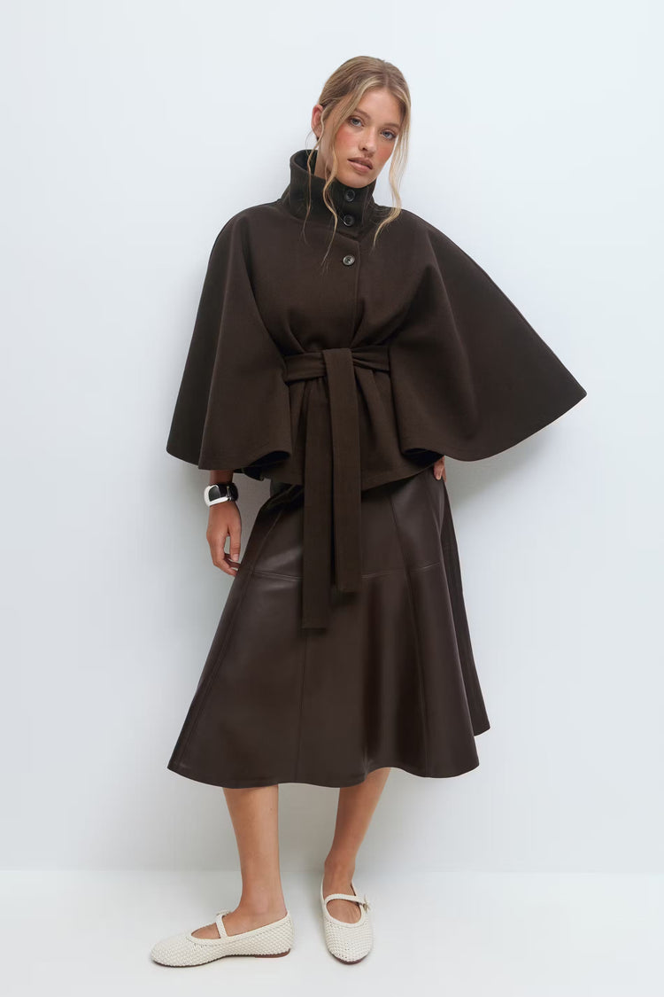 Manteau femme chic, coupe cape ample, col montant, ceinture pour une silhouette élégante.
