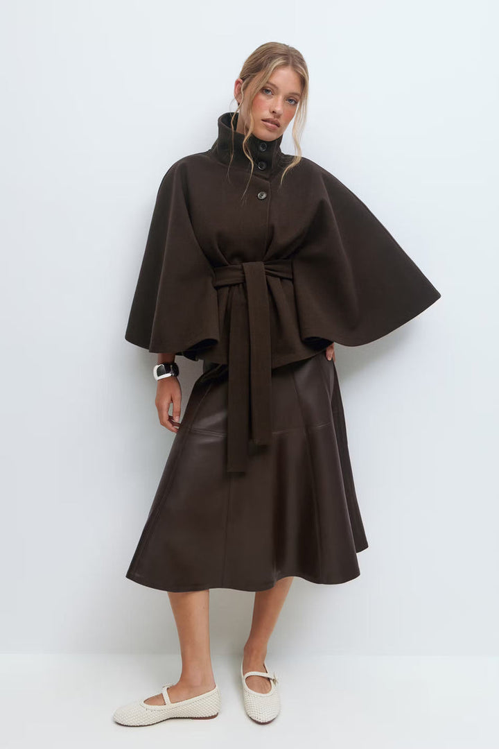 Manteau femme chic, coupe cape ample, col montant, ceinture pour une silhouette élégante.