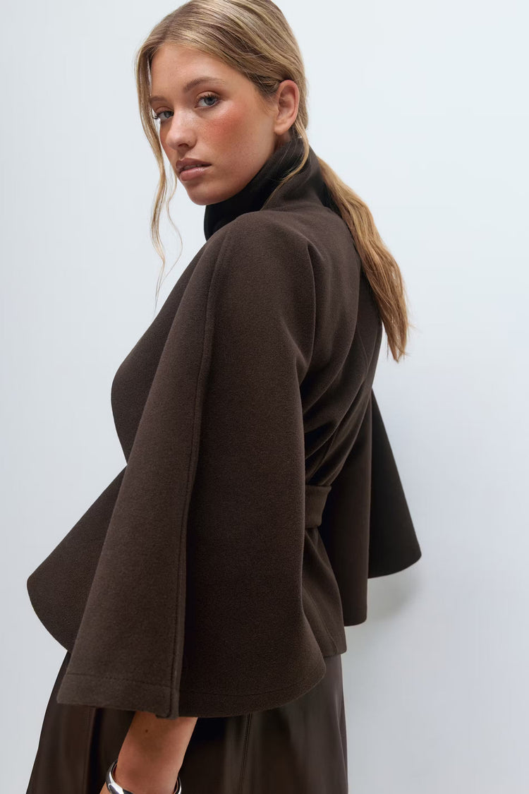 Veste cape d'hiver pour femme, col montant, ceinturée, offrant chaleur et style raffiné.