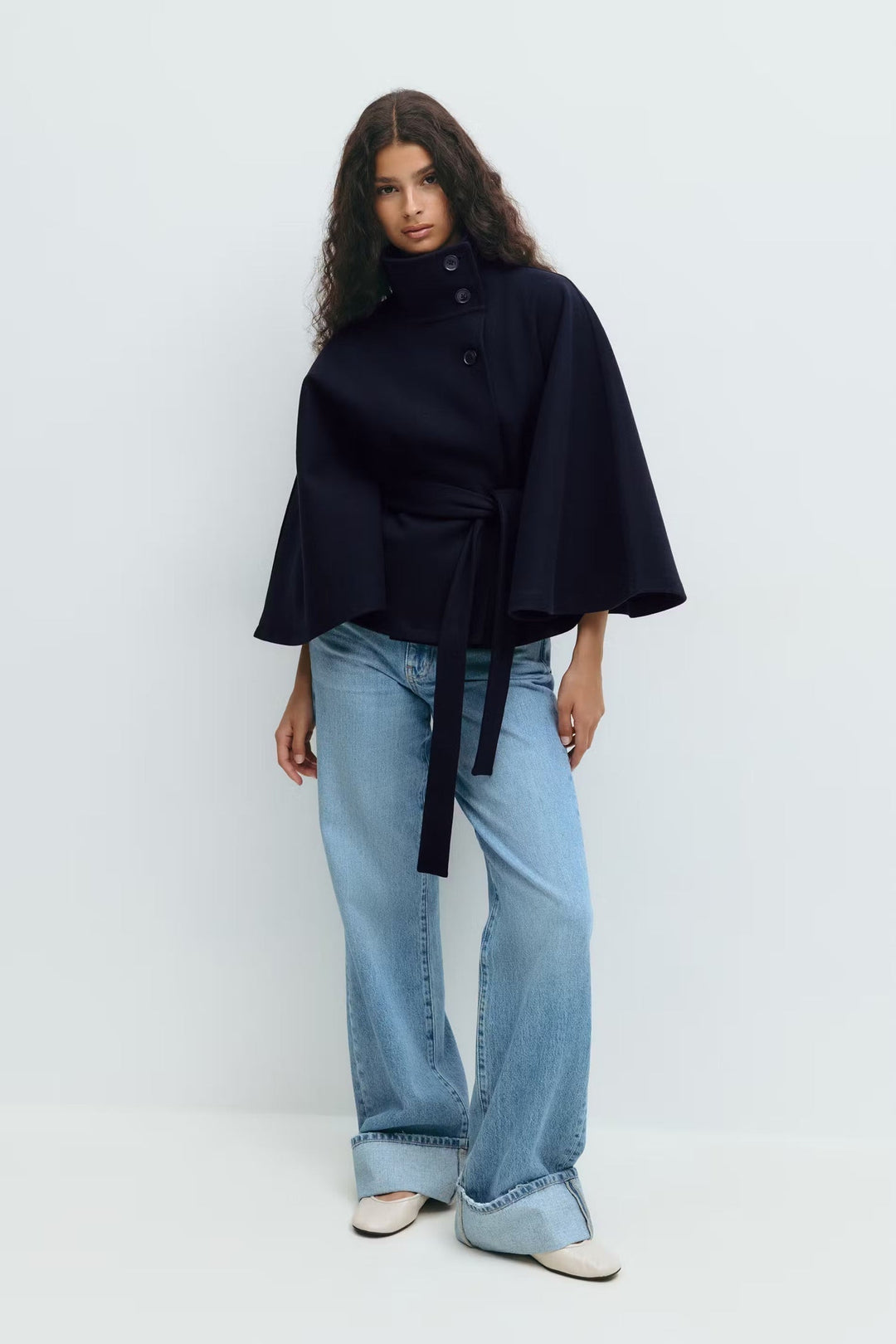 Manteau femme type cape, col montant, ceinturé, vêtement hivernal chic et confortable.