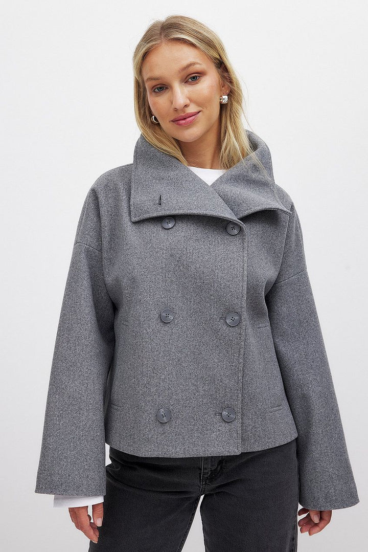 Manteau court femme élégant double boutonnage. Veste classique chic pour automne/hiver. Disponible gris, noir, bleu marine.