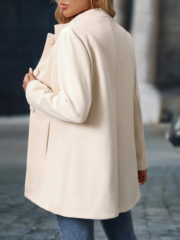 Détail du col montant et des boutons sur le manteau élégant d'hiver pour femme.