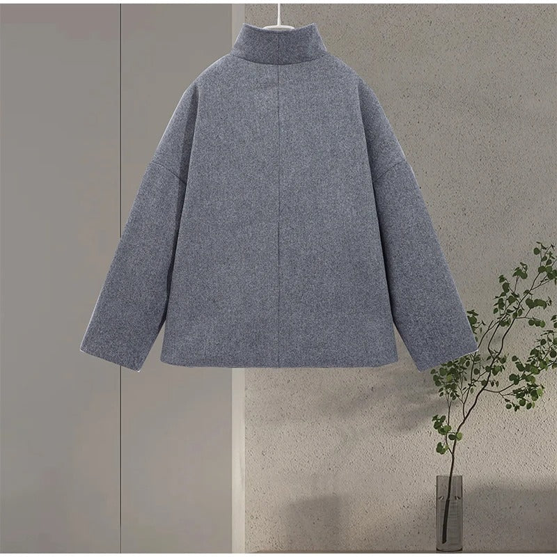 Manteau femme élégant gris, col montant, boutonné. Vêtement d'hiver chic pour mode professionnelle.