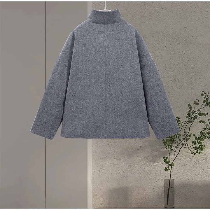 Manteau femme élégant gris, col montant, boutonné. Vêtement d'hiver chic pour mode professionnelle.