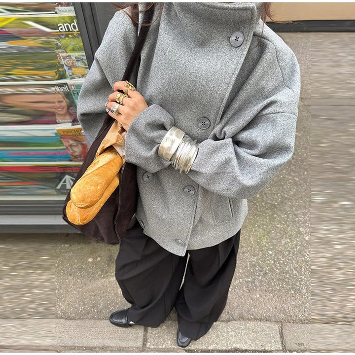 Extérieur femme : manteau élégant gris/noir, col montant. Idéal pour rester chic et chaude en hiver.