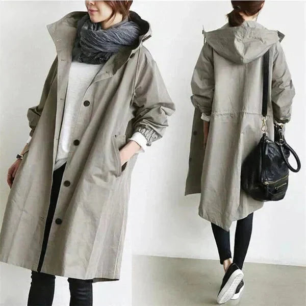 Manteau imperméable femme urbain noir avec capuche oversize, idéal pour la pluie et le vent de ville.