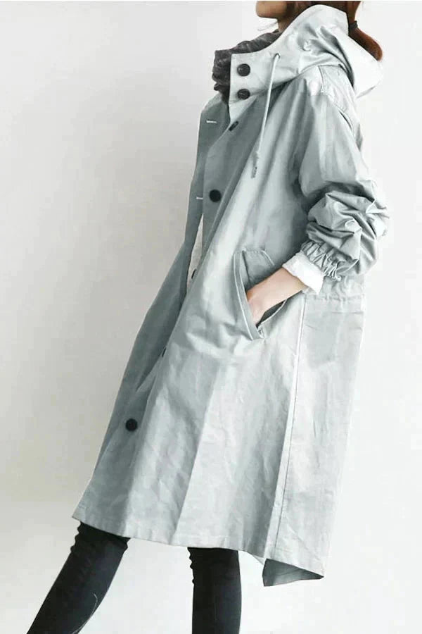 Manteau de pluie respirant pour femme, couleur beige, avec capuche oversize, parfait pour un look urbain chic.