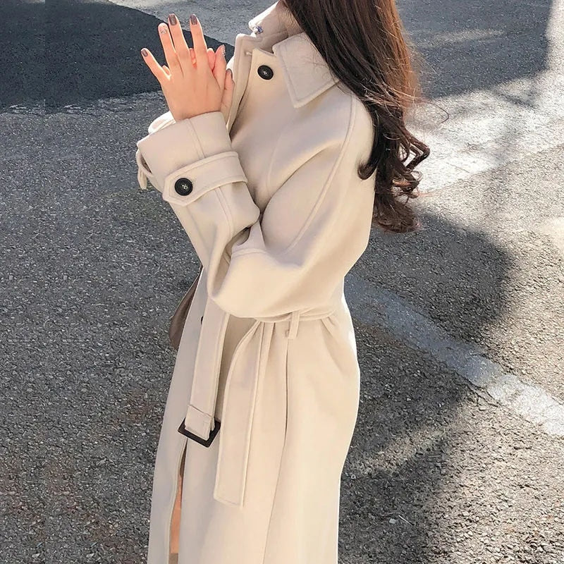 Manteau élégant beige ceinturé pour femme, style raffiné. Idéal mode automne-hiver chic.