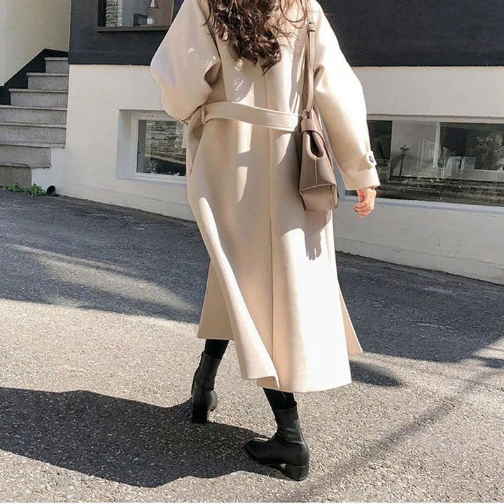 Trench-coat femme beige chameau ceinturé, coupe classique. Parfait pour une allure élégante en hiver.