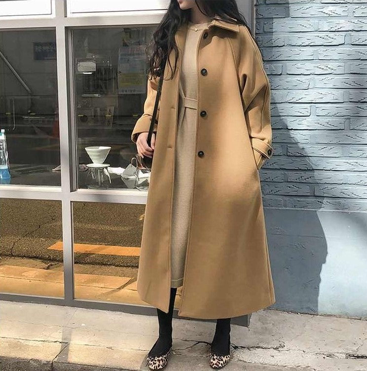 Manteau long femme élégant, silhouette ajustée, couleur sombre, idéal pour hiver, allie style et chaleur, look intemporel.