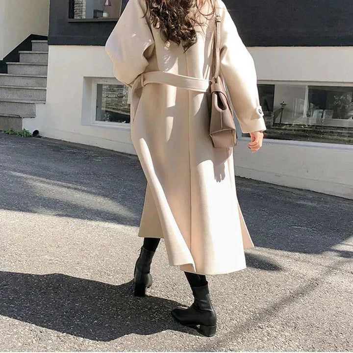 Manteau long femme élégant, silhouette ajustée, couleur sombre, idéal pour hiver, allie style et chaleur, look intemporel.
