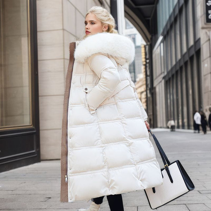 Femme en manteau long matelassé avec col fourrure, look hivernal chic et protection optimale contre le froid.