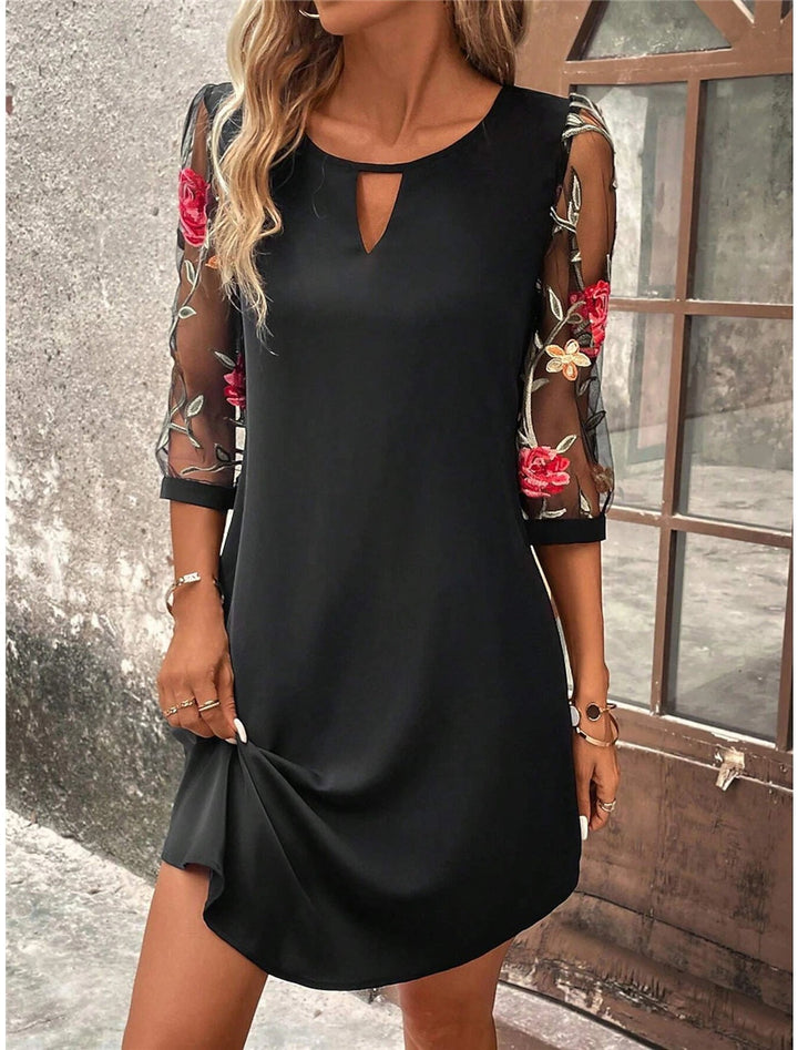 "Mini robe chemise fleurie pour femme, élégante, coupe courte, imprimé vibrant, idéale été, style léger et raffiné."