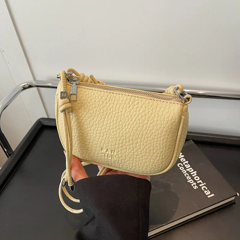 Petit sac femme compact en similicuir noir, avec bandoulière, idéal pour un style chic et moderne.