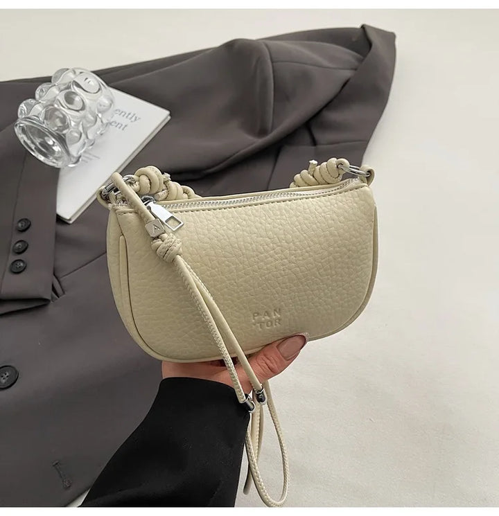 Sac à main femme moderne, mini et chic, en similicuir noir, parfait pour compléter une tenue élégante.